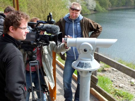 Bild 1: Auf Augenhöhe mit den Fernseh-Profis: Pascal Schäfer, Praktikant des Commerzbank-Umweltpraktikums (links) 2013 gemeinsam mit einem WDR-Team beim Vorbereiten des Drehs an der neuen Bird Watching Station am Urftsee. Dort drehte der filmaffine Studen