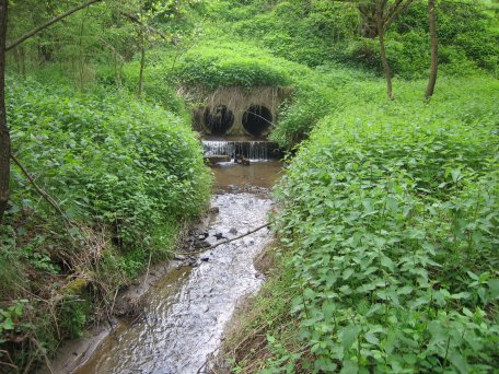 Bild 1: So sah der Bachlauf vorher aus: Der Helingsbach wurde in einem Rohr durch den Damm geleitet.
