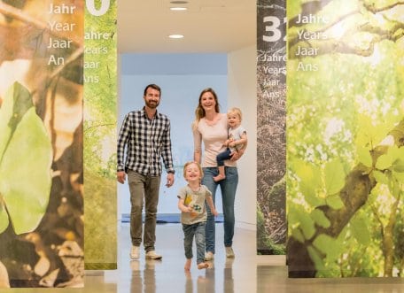 Das Bild zeigt eine Familie, die durch die Erlebnisausstellung "Wildnis(t)räume" schlendert.