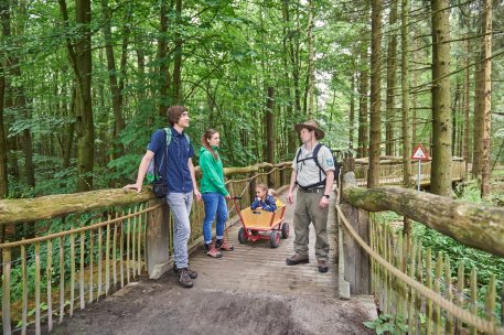 Das Bild zeigt einen Nationalpark-Ranger mit einer Besuchergruppe auf dem Wilden Weg - einem barrierefreien Naturerlebnisangebot im Kermeter.