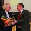 Der Forstamtsleiter aus dem Münsterland, Heinz-Peter „Pit“ Hochhäuser, überreicht im Namen der Regionalen Forstamtsleiter kulinarische Köstlichkeiten aus dem Münsterland an Henning Walter.