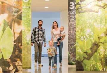 Das Bild zeigt eine Familie, die durch die Erlebnisausstellung "Wildnis(t)räume" schlendert.