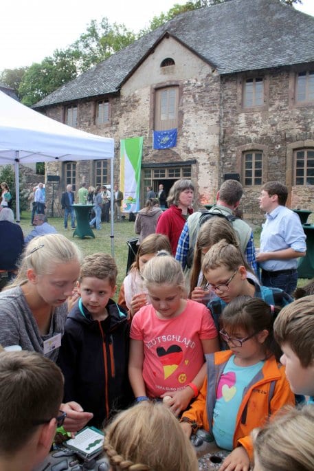 Grundschüler aus Dreiborn studieren mit Begeisterung das Spiel am Bachmodell des Life+-Projektes „Wald-Wasser-Wildnis“. (Foto: A. Simantke/Nationalparkverwaltung Eifel)