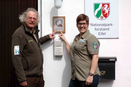 Leiter der Nationalparkverwaltung Henning Walter und Qualitätscoach Martina Höller freuen sich über das neue Zertifizierungs-Schild am Eingang der Nationalparkverwaltung.
