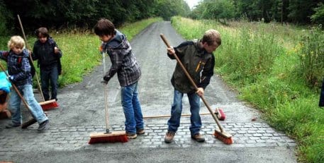 Mit Eifer halten die Fußballkinder des SV Nierfeld das Blindenleitsystem des neuen barrierefreien Naturerlebnisraumes „Wilder Kermeter“ frei.