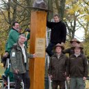 Mitarbeiter der Holzbauwerkstatt befestigen Rangerhut auf der 2,50 Meter hohen Holzstele