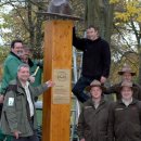 Mitarbeiter der Holzbauwerkstatt befestigen Rangerhut auf der 2,50 Meter hohen Holzstele